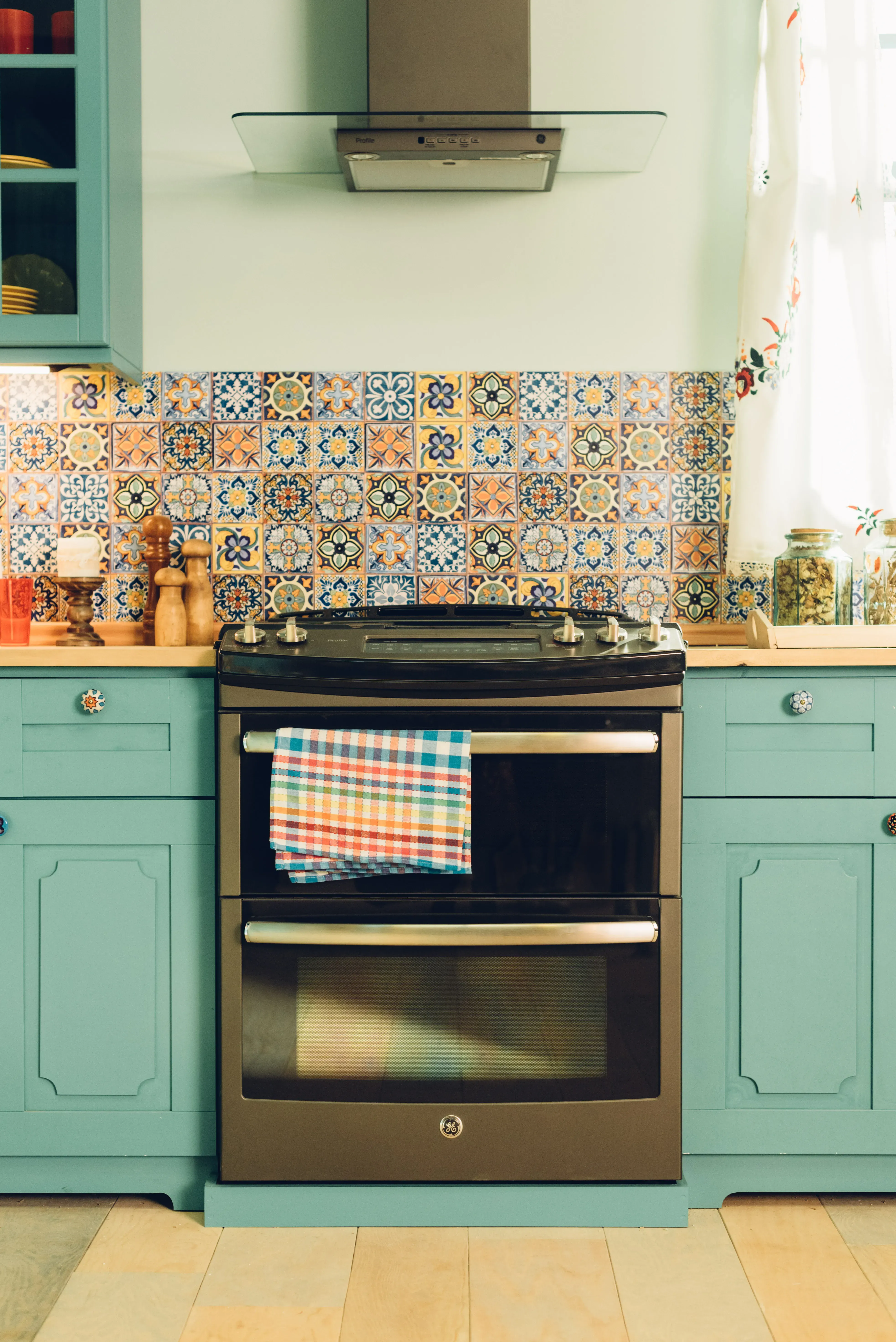 GE Slate Double Oven Range & Venthood in a beautiful kitchen featuring pops of color.